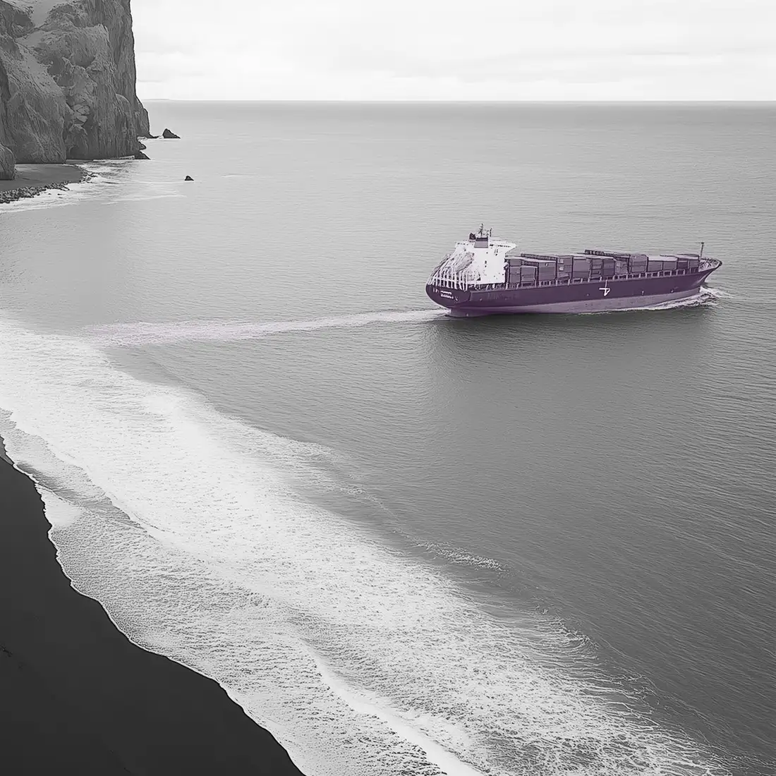 A container ship off a black-sand coastline