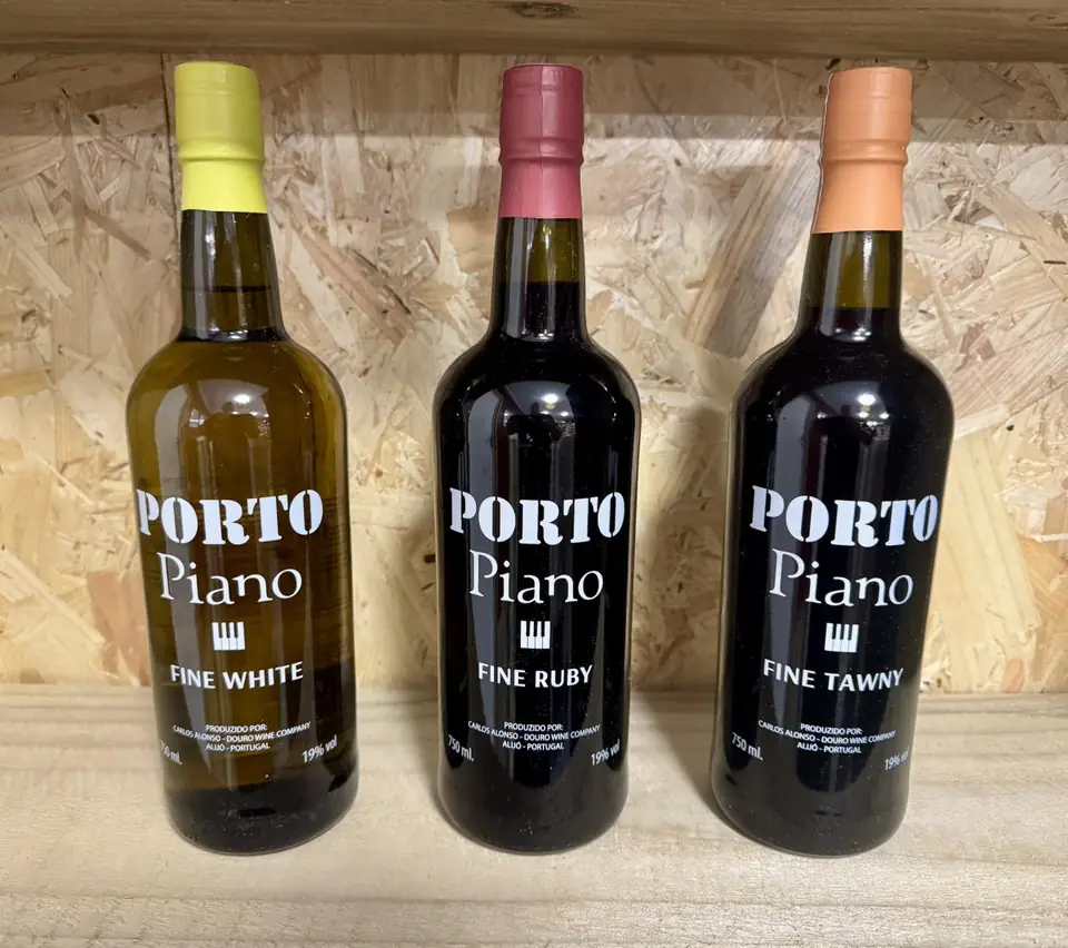 Three bottles of Porto Piano port on a wooden shelf at Givino