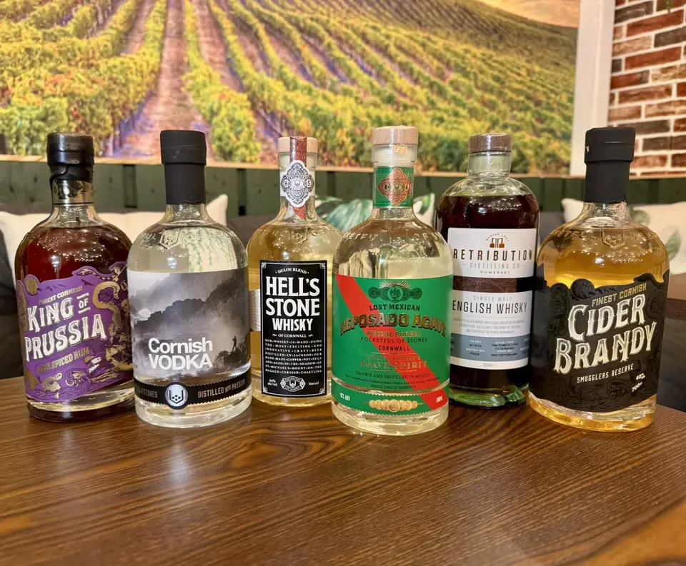 Craft spirits on a wooden counter in front of a vineyard mural at Givino