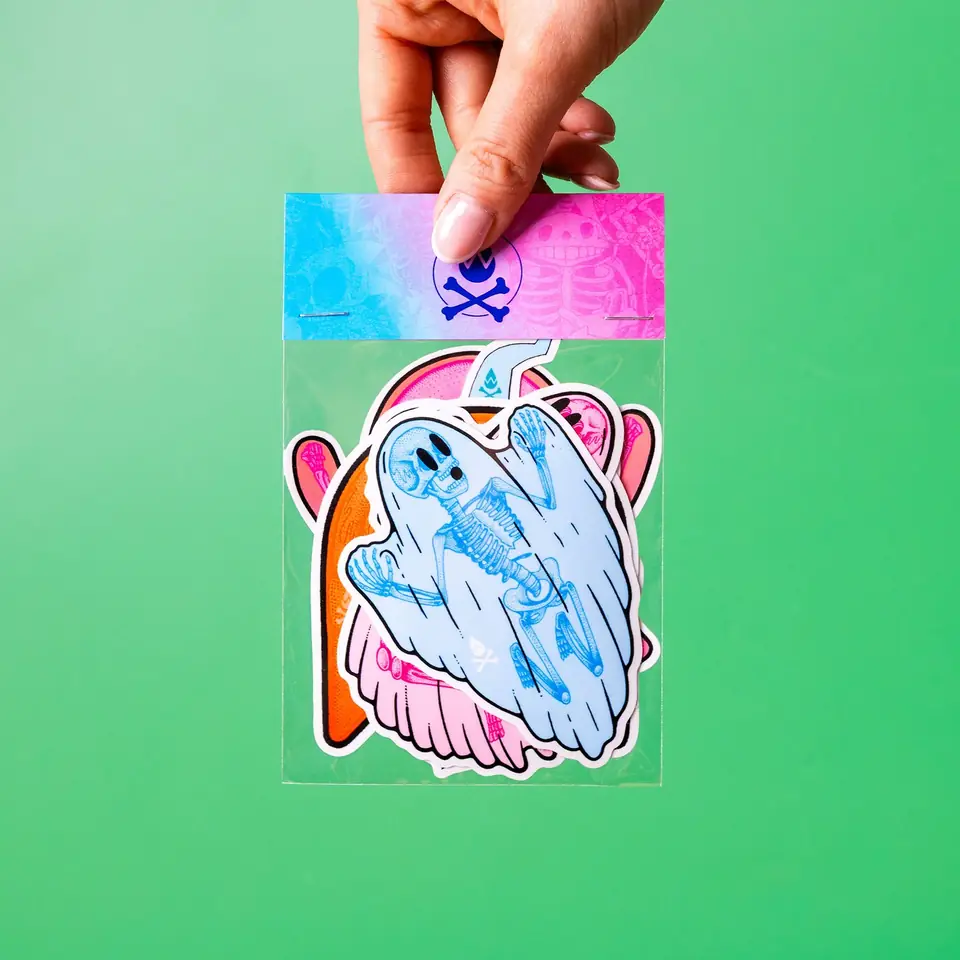 A hand holding a holographic ghost sticker against green