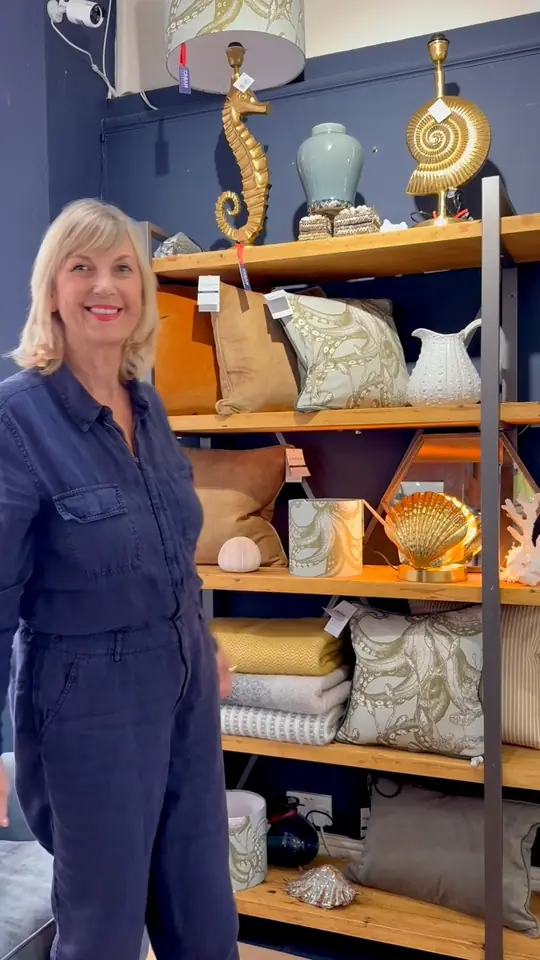 The Cream Cornwall founder standing among shelves of homeware in her shop