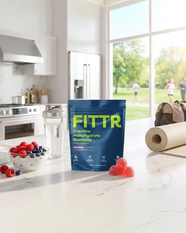 A pouch of Fittr creatine gummies on a bright kitchen counter with berries