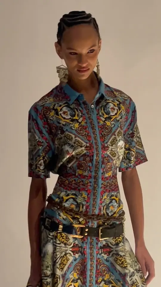 A model in a patterned silk shirt and trousers