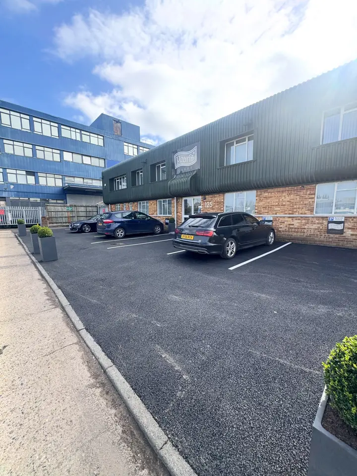 A newly surfaced car park beside an office building
