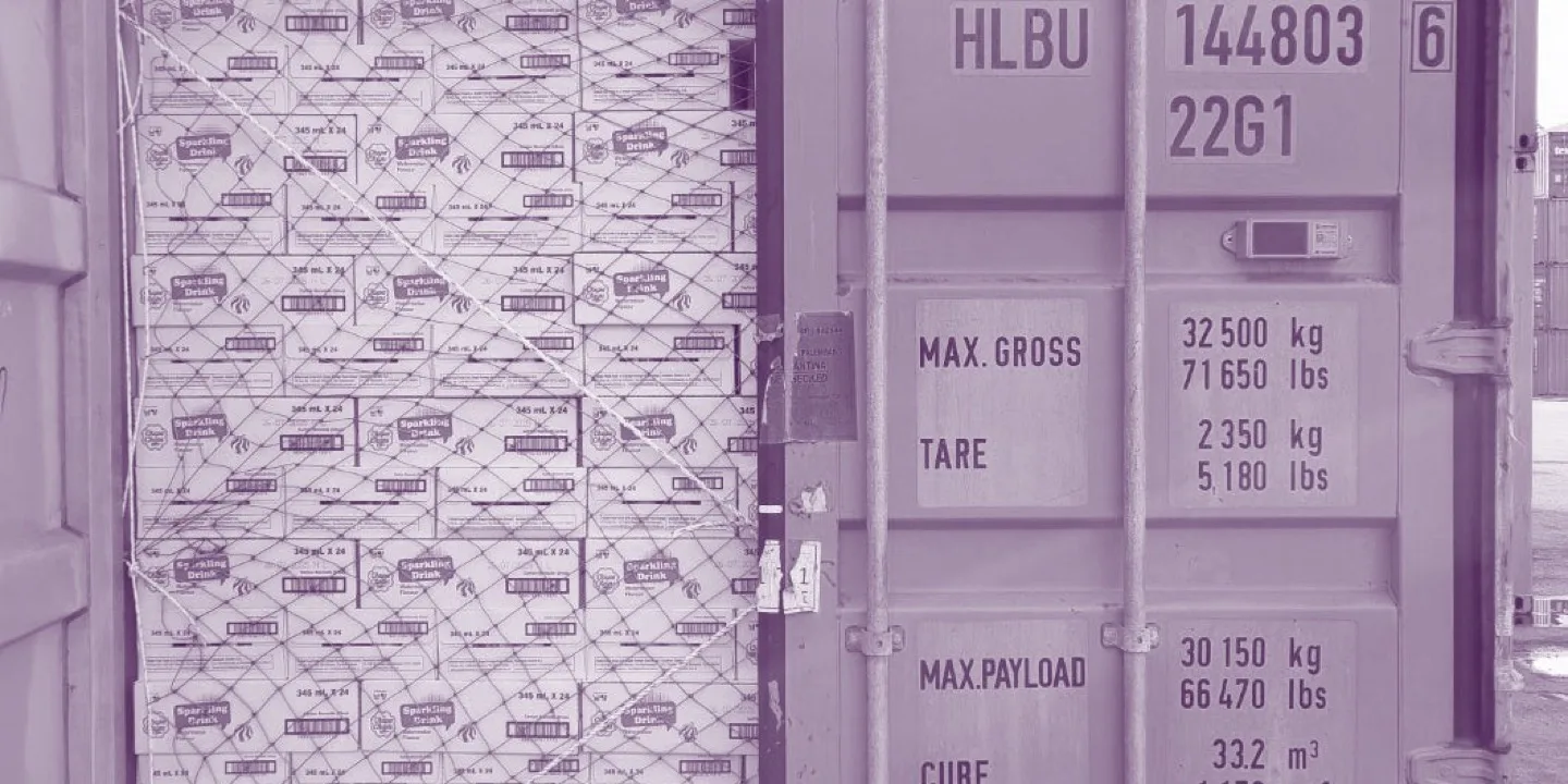 A shipping container packed to the roof with cases of soft drinks, its payload plate reading 30,150kg