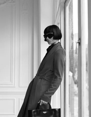 A Bessette coat and bag, shot on film beside tall windows