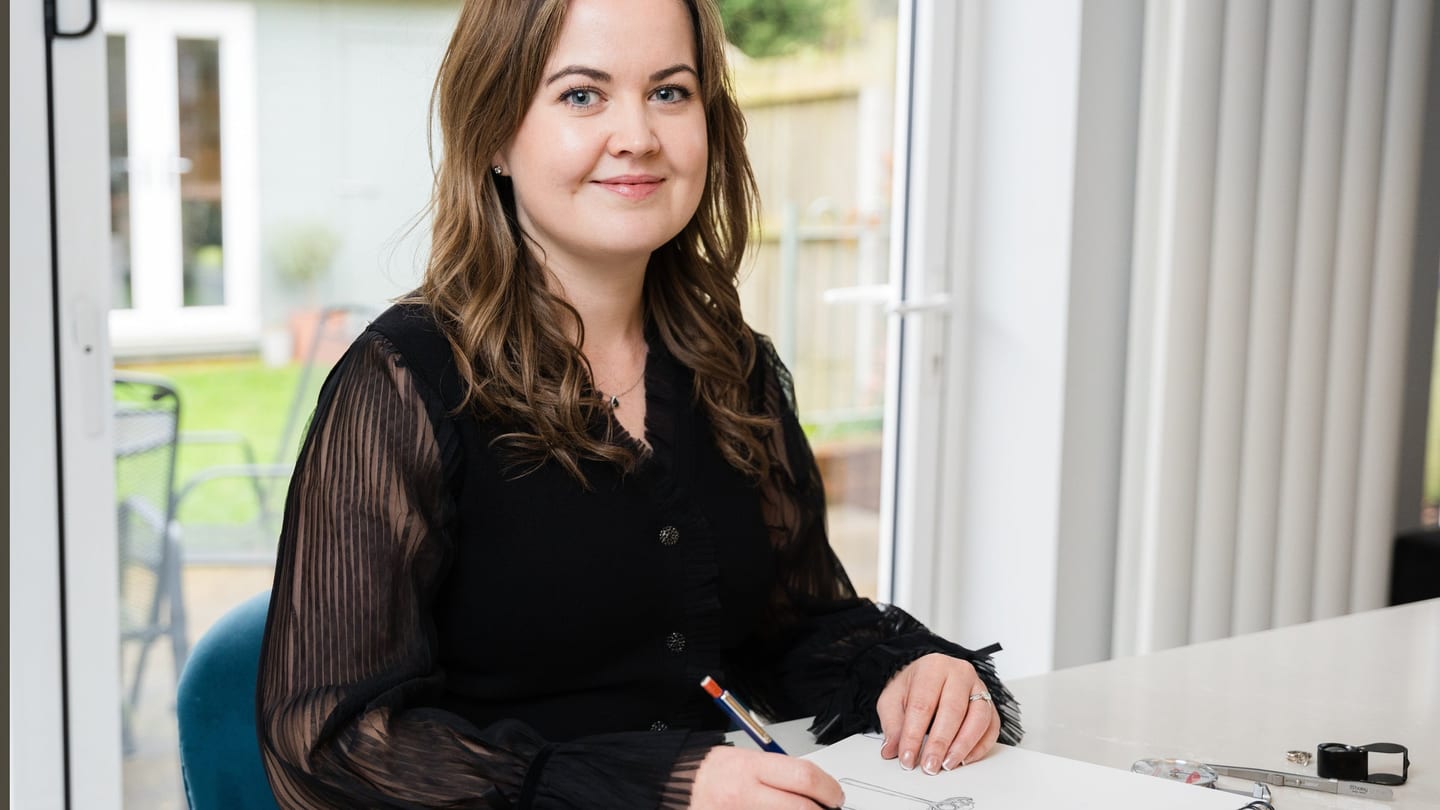 Poppy Elder at her desk, sketching a ring design
